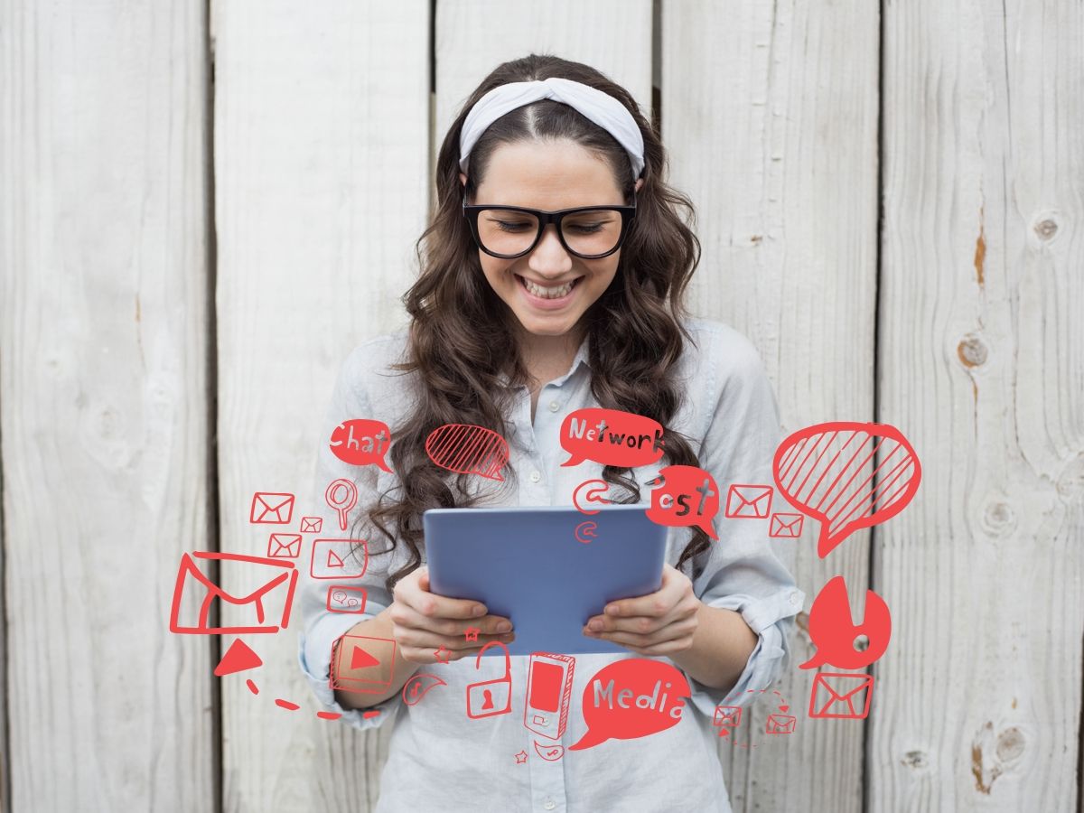 Image of a woman wearing glasses looking at a tablet, with red social media icons surrounding - The most important metrics for content marketing - Image